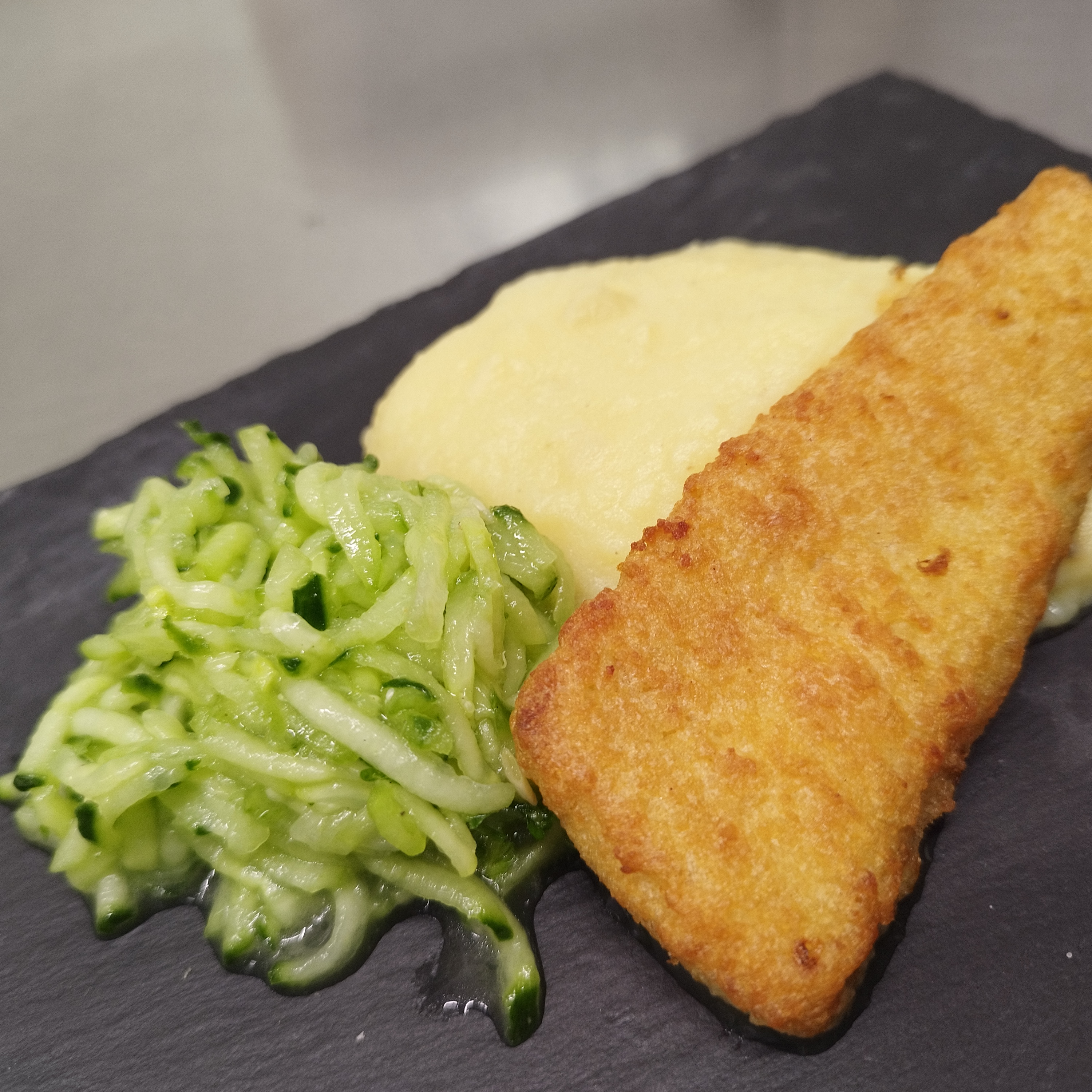 Paniertes Fischfilet mit Kartoffelpüree und Gurkensalat